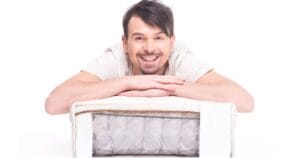 Een lachende man liggend op een matras